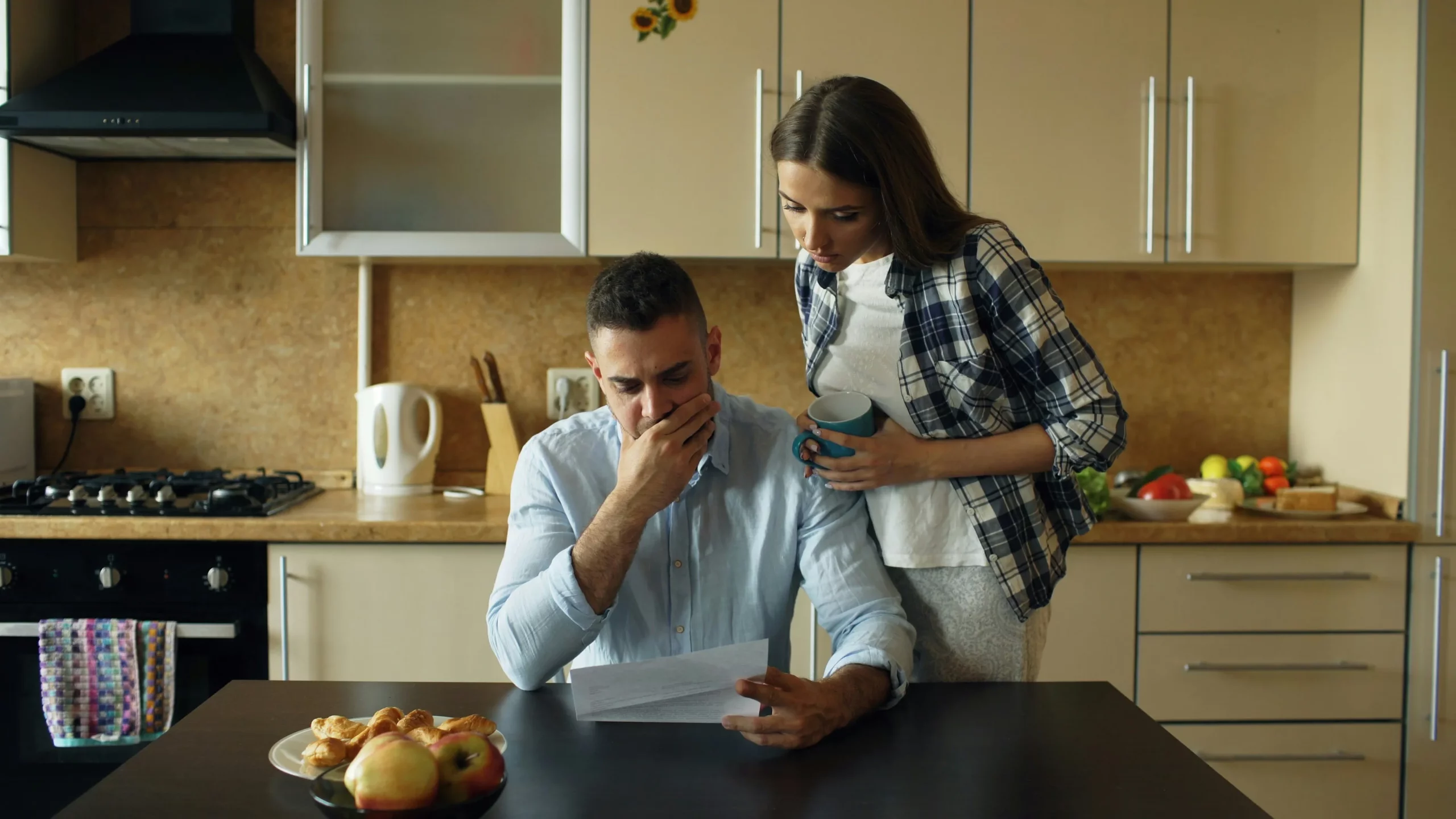 Couple inquiet lisant une facture dans la cuisine