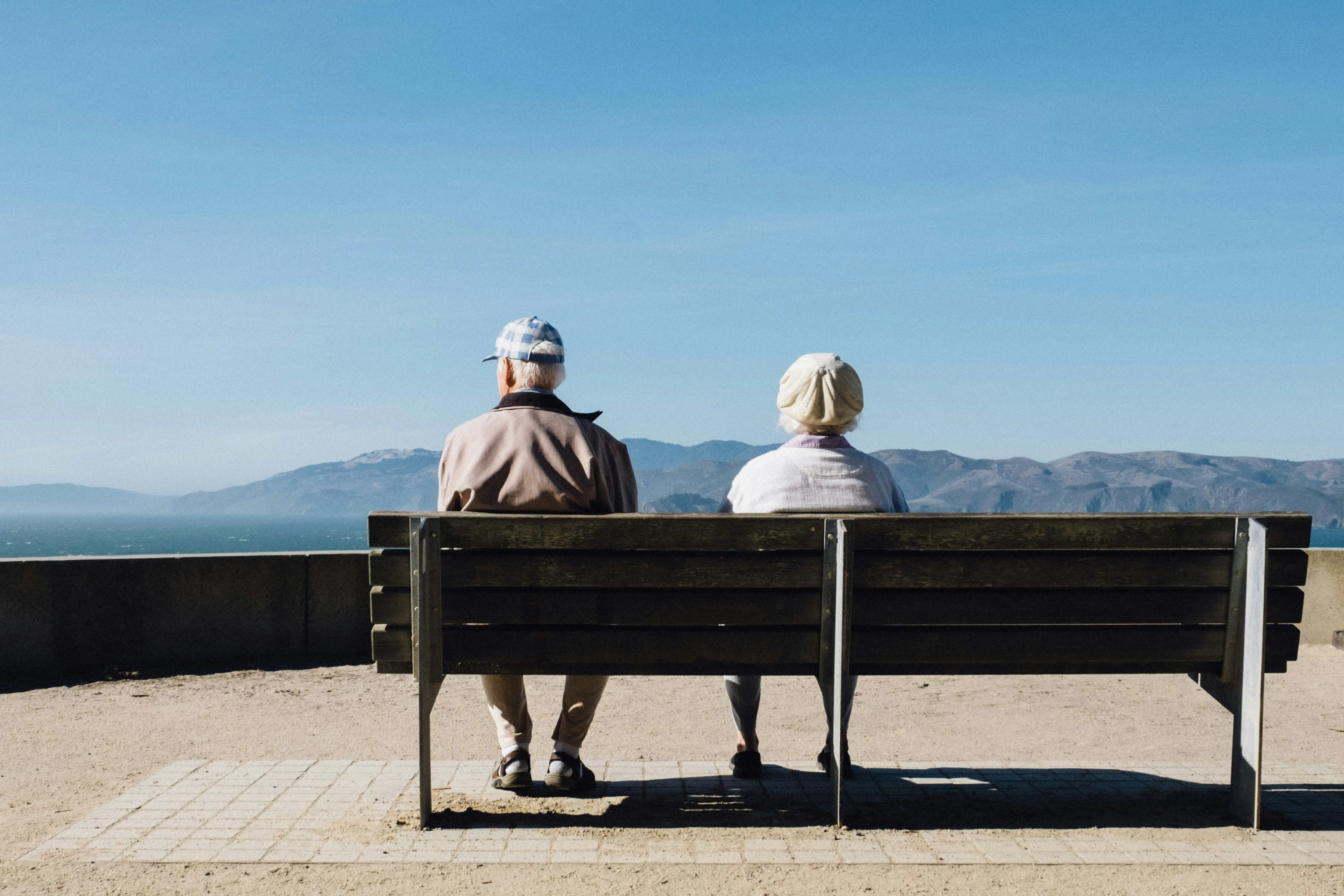 Couple de retraités assis sur un banc face à la mer
