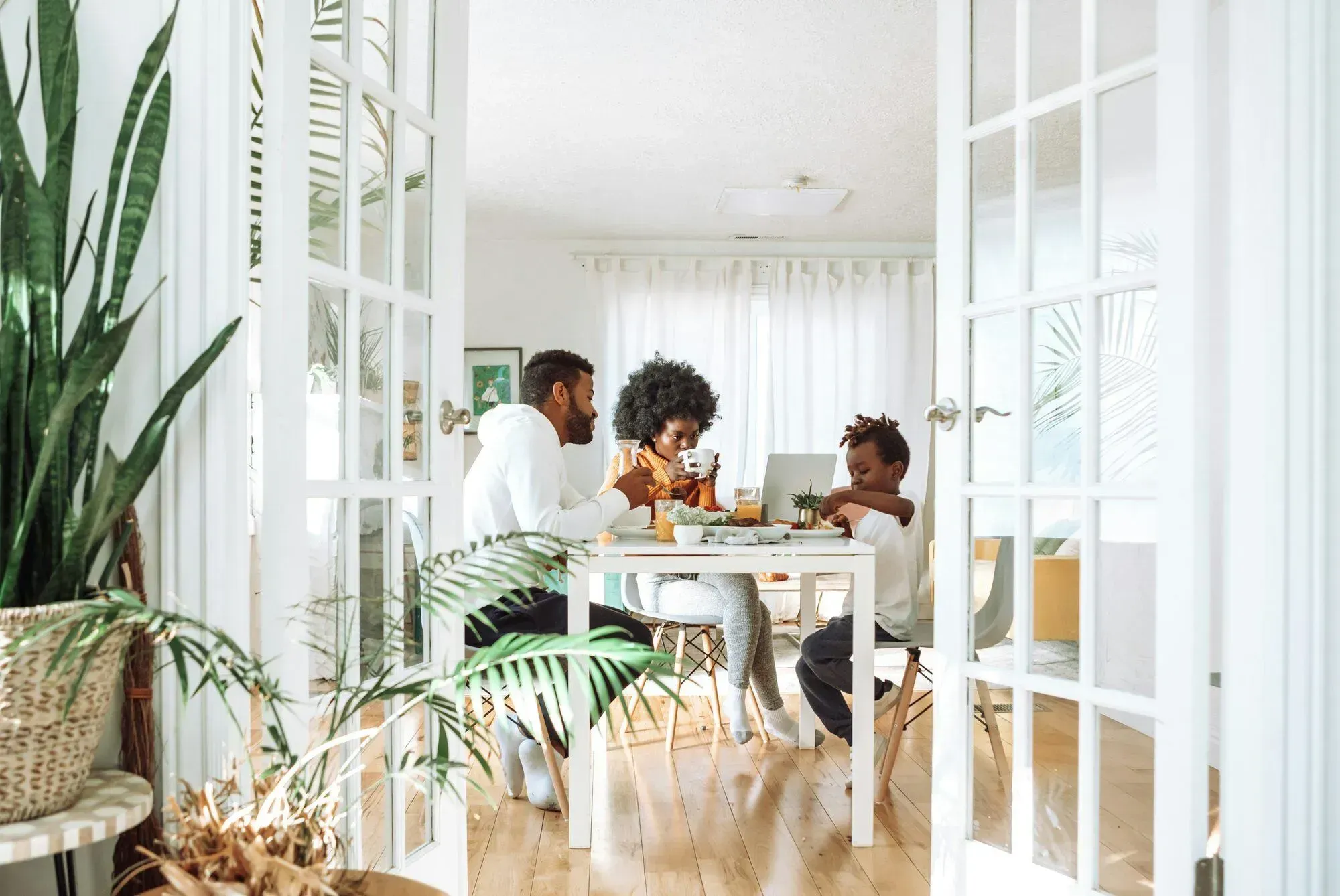 Famille prenant son petit-déjeuner à table dans une cuisine lumineuse