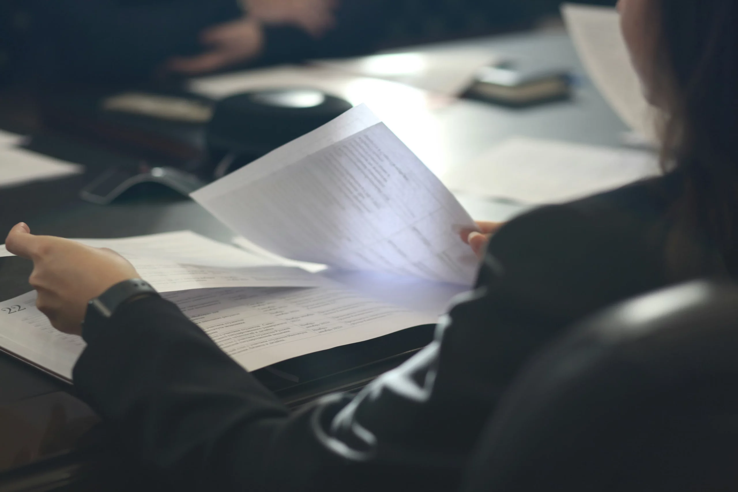 Mains feuilletant des documents sur un bureau